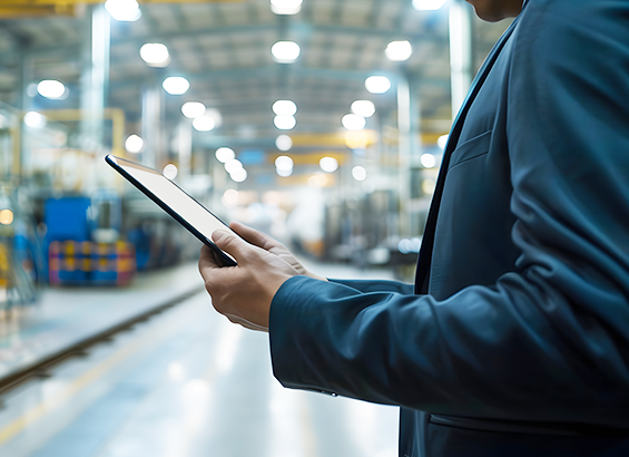 Professional businessman using digital tablet on industrial factory shop floor 