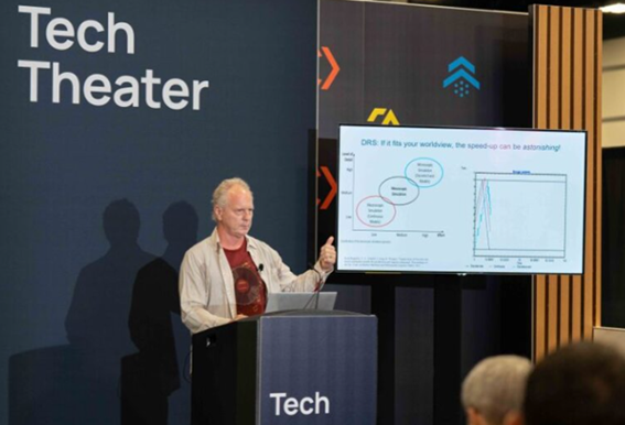 Speaker on a podium presenting at the Tech Theater